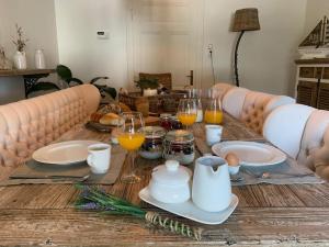 a wooden table with breakfast foods and drinks on it at B&B Holset70 in Lemiers