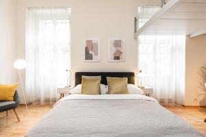 a bedroom with a large bed and two windows at Prague Center Apartments in Prague
