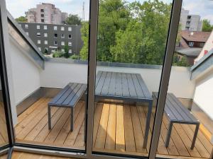 einen Balkon mit einer Bank und einem Tisch in der Unterkunft AB Kornwestheim in Kornwestheim