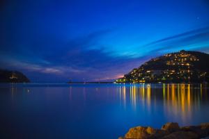 a view of a lake at night with a mountain at Hotel Brismar in Port d’Andratx