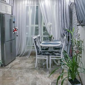 キーウにあるRent-Kiev Apartment on LuxKlavdievskayaの窓付きの客室で、白いテーブルと椅子が備わります。