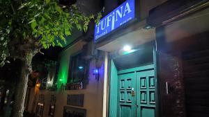 un cartello sul lato di un edificio di notte di Tufina Hostel a Tirana
