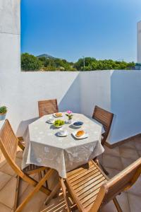 a table and chairs with food on a balcony at HVAR apartments 8 min to the beach in Hvar
