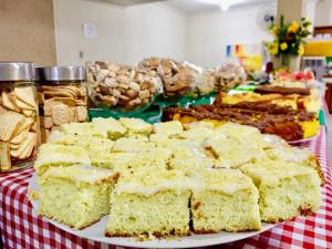 a table with a plate of cakes and other desserts at Hotel Esmig in Venda Nova do Imigrante