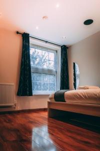 1 dormitorio con 2 camas y ventana en Hotel Quality Stay,2 bed Apartment near the City Centre, 2min Walk from Metro Station, en Londres