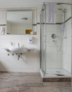 a bathroom with a sink and a shower at Aristo Hotel in Filderstadt