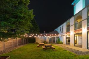 a courtyard with picnic tables and lights at night at The Redwood Riverwalk, a boutique hotel in Fortuna
