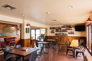 a restaurant with tables and chairs and a tv at The Redwood Riverwalk, a boutique hotel in Fortuna
