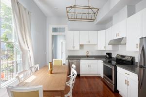 a kitchen with a wooden table and white cabinets at Sonder at Uptown in New Orleans