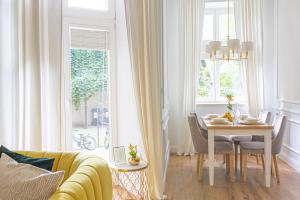 salon ze stołem i żółtą kanapą w obiekcie Apartament Golden Place w Krakowie