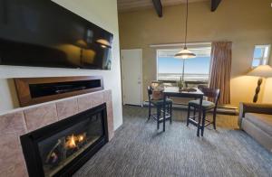 a living room with a fireplace and a table and chairs at Fireside Motel in Yachats