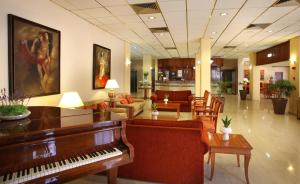 a lobby with a piano and a living room at Odysseia Hotel Kapetanios in Limassol