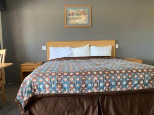- une chambre avec un lit et une couette colorée dans l'établissement Cinderella Motel, à Wasco