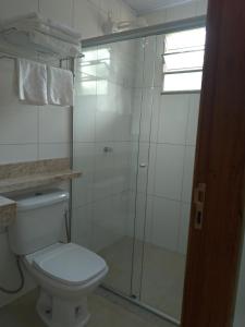 a bathroom with a toilet and a glass shower at Recanto na Floresta in Rio Branco