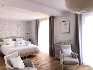 une chambre avec un lit et deux chaises dans l'établissement Le Cœur de la Bastide - Adult only, à Carcassonne