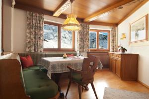 una sala da pranzo con tavolo, sedie e finestre di Gasthof Valluga a Sankt Christoph am Arlberg