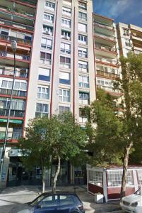 un coche aparcado frente a un edificio alto en Pensión La Estrella en Zaragoza