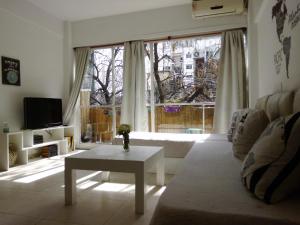 uma sala de estar com uma mesa em frente a uma grande janela em Palermo Soho em Buenos Aires