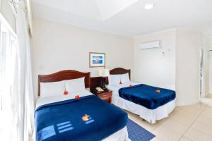a hotel room with two beds with blue sheets at Bay Gardens Marina Haven in Gros Islet