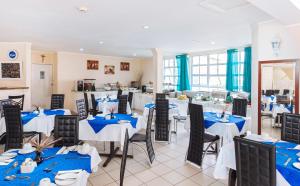a restaurant with blue and white tables and chairs at Bay Gardens Marina Haven in Gros Islet