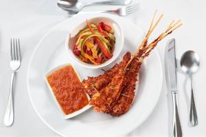 a plate of food with meat and a bowl of salad at Bay Gardens Marina Haven in Gros Islet