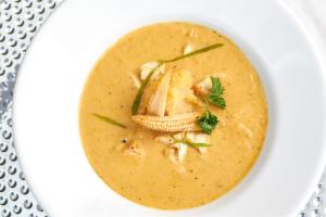 a white bowl of soup on a white plate at Bay Gardens Marina Haven in Gros Islet