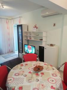 Pokój ze stołem, czerwonymi krzesłami i telewizorem w obiekcie Apartman Đurđica w mieście Lovran