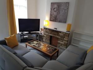 a living room with a couch and a fireplace at Stylish living with considered workspace in Norwich