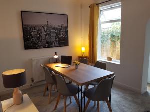 a dining room with a table with chairs and a laptop at Stylish living with considered workspace in Norwich