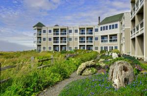 a large building with flowers in front of it at Overleaf Lodge and Spa in Yachats