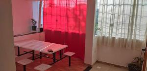 a table in a room with a red wall at Pousada albarquel in Serra