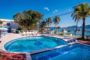 a swimming pool with a view of the water at Hotel Ilhabela in Ilhabela