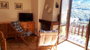 uma sala de estar com lareira e televisão em Vacanze Valmalenco em Chiesa in Valmalenco