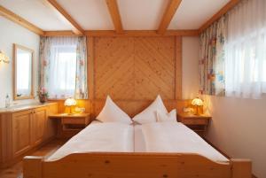 サンクト・クリストフ・アム・アールベルクにあるGasthof Vallugaのベッドルーム1室(大型ベッド1台、テーブル2台、ランプ2つ付)