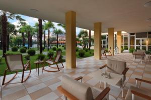 - un hall avec des chaises, des tables et des palmiers dans l'établissement Hotel Savoia Thermae & SPA, à Abano Terme