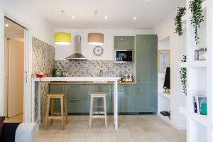 una cocina con armarios verdes y una barra con taburetes en Calaba Stadio, en Nápoles