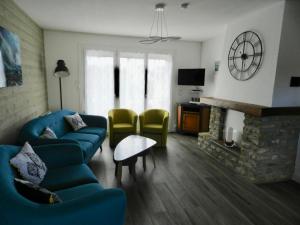 a living room with a blue couch and a fireplace at La Maison Blanche in Saint-Laurent-sur-Mer