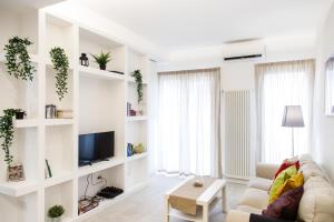 sala de estar con estanterías blancas y sofá en Calaba Stadio, en Nápoles