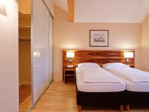 a bedroom with two beds and a table and two lamps at Holiday Apartments by Das Grüne Hotel zur Post - 100 % BIO & Villa Ceconi in Salzburg +100 photos