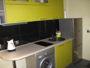a kitchen with a sink and a washing machine at Jūra in Ventspils