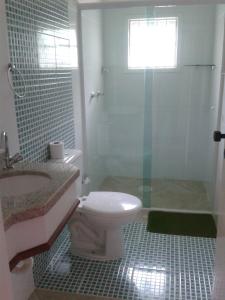 a bathroom with a toilet and a sink and a shower at Hotel Areia Dourada in Peruíbe
