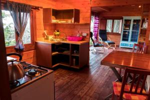 cocina con fogones y mesa en una cabaña en Finca Pura Vida Blockhaus, en Mazo
