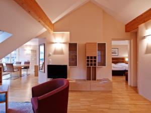 een grote woonkamer met een televisie en een bed bij Holiday Apartments by Das Grüne Hotel zur Post - 100 % BIO & Villa Ceconi in Salzburg