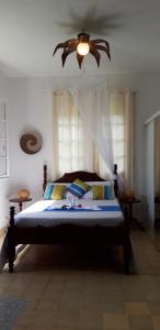 a bedroom with a bed with a ceiling fan at Ti Cajou in Baie-Mahault