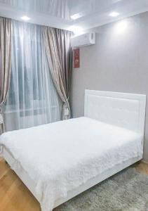een wit bed in een kamer met een raam bij Rent-Kiev Apartment on LuxKlavdievskaya in Kiev