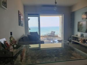 uma sala de estar com vista para o oceano em Periyiali Beach Sunset Suite A7 em Pervolia