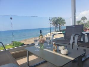 uma mesa com dois copos e uma garrafa de vinho em Periyiali Beach Sunset Suite A7 em Pervolia