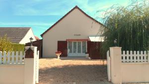 a white house with a white fence and a gate at Les Guernazelles in Bracieux