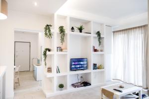 a living room with white shelves and a tv at Calaba Stadio in Naples