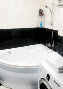 a bathroom with a white tub and a washing machine at Rent-Kiev Apartment on LuxKlavdievskaya in Kyiv +17 photos
